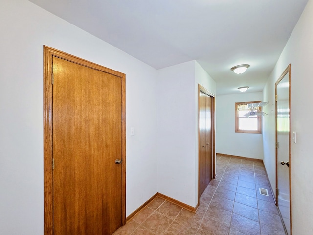 hall with light tile patterned floors