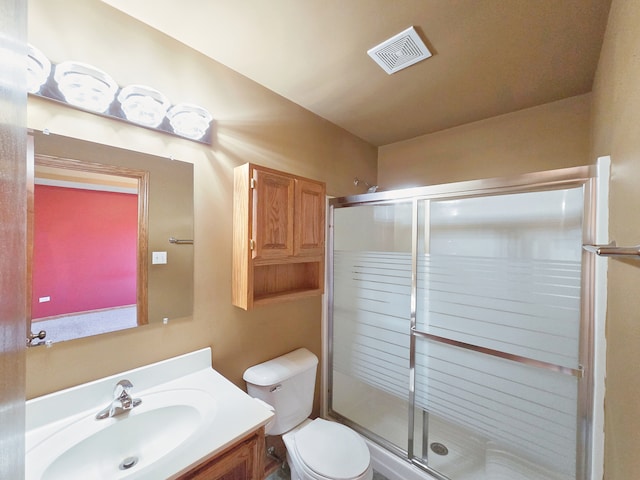 bathroom featuring toilet, an enclosed shower, and vanity