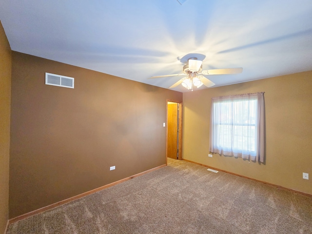 spare room featuring ceiling fan and carpet