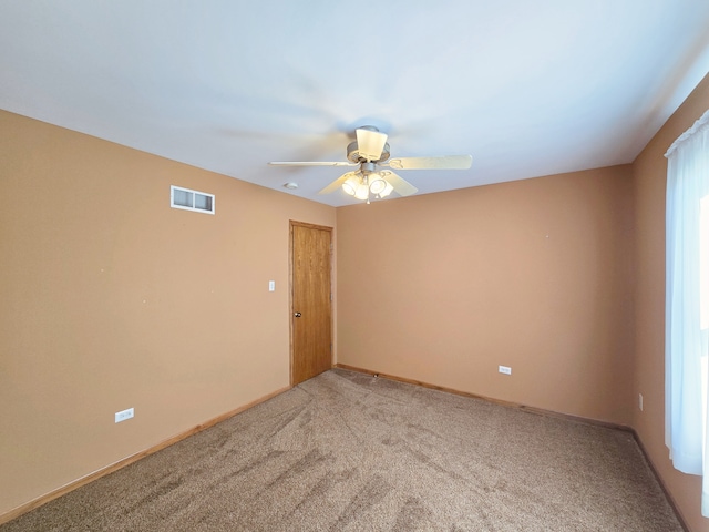 carpeted spare room featuring ceiling fan