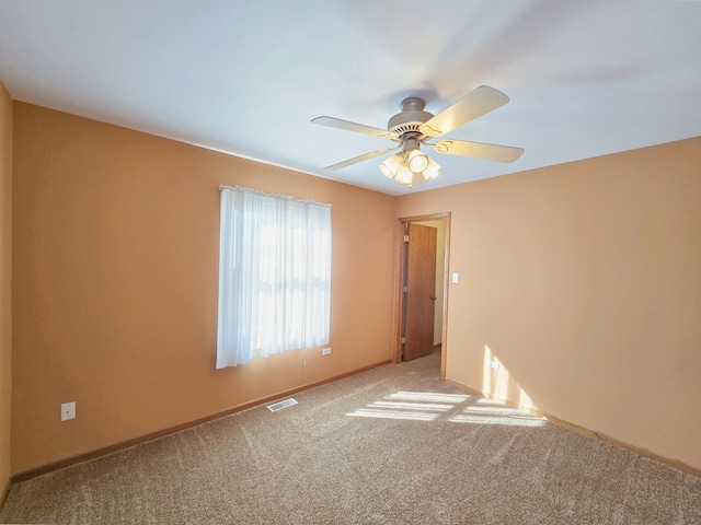 empty room with ceiling fan and carpet floors