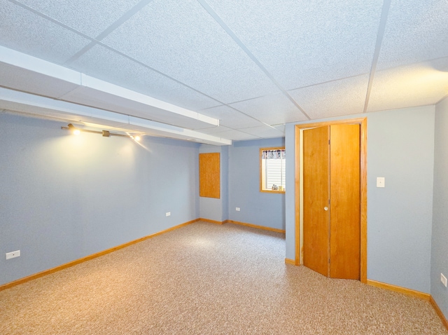 basement with a drop ceiling and carpet