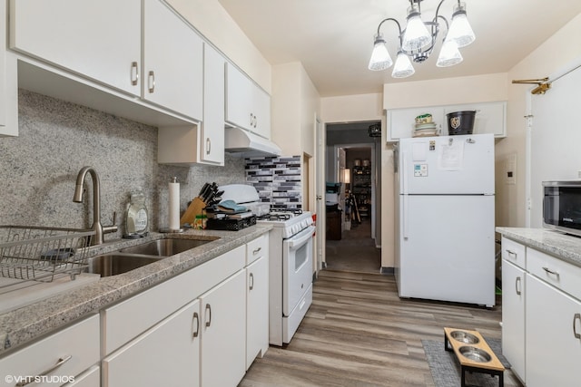 kitchen with white cabinets, light wood-type flooring, and white appliances