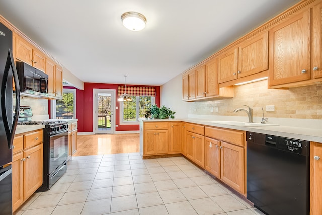 kitchen featuring sink, tasteful backsplash, black appliances, and decorative light fixtures