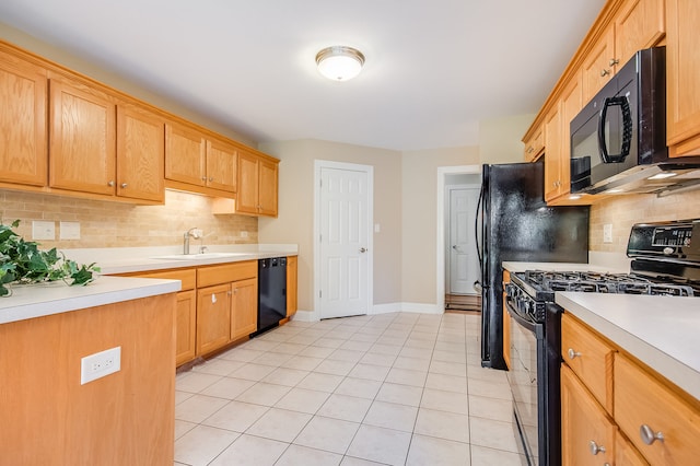 kitchen featuring sink, tasteful backsplash, black appliances, and light tile patterned flooring