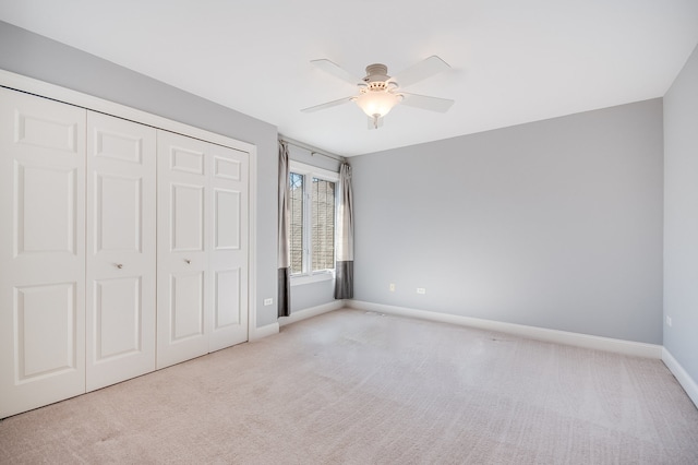 unfurnished bedroom with a closet, ceiling fan, and light carpet