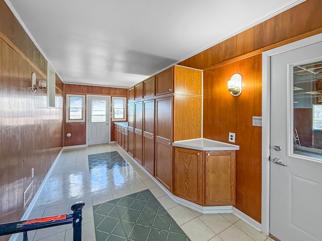 interior space with wooden walls and light tile patterned flooring