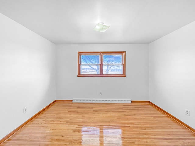 unfurnished room with a baseboard radiator and light hardwood / wood-style flooring