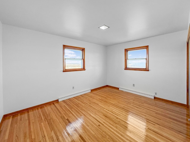 spare room featuring light hardwood / wood-style floors and a baseboard heating unit