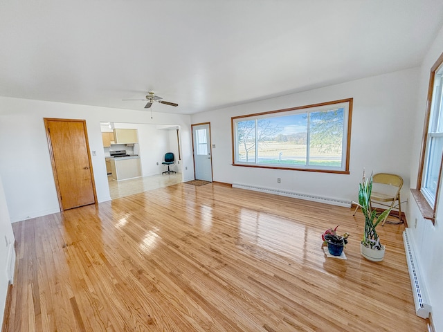 unfurnished living room featuring light wood-type flooring, ceiling fan, and a baseboard radiator