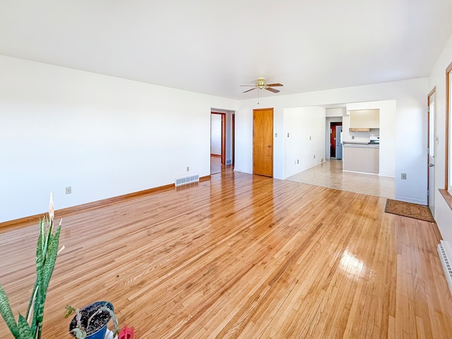 unfurnished living room featuring ceiling fan and light hardwood / wood-style flooring