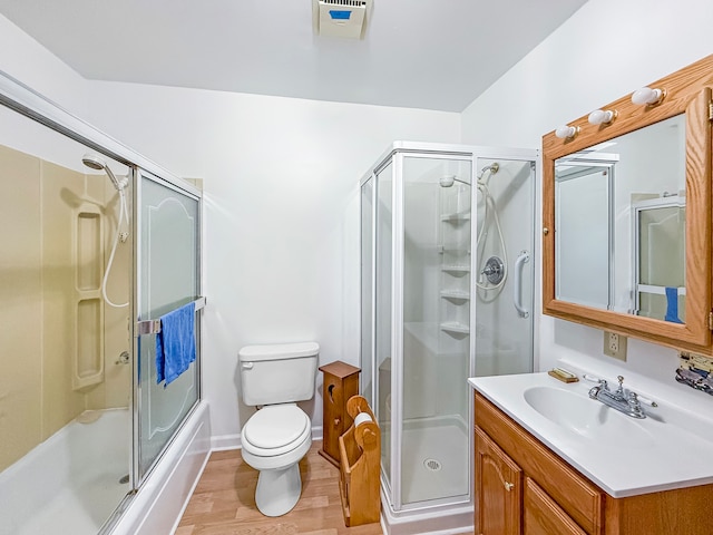 full bathroom with toilet, vanity, hardwood / wood-style flooring, and shower / bath combination with glass door