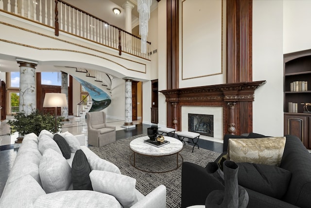 living room featuring a high ceiling, built in features, and ornate columns