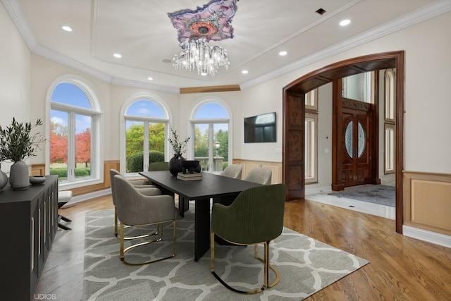 dining space with ornamental molding, light hardwood / wood-style flooring, and a chandelier