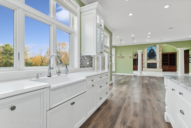 kitchen with ornate columns, a healthy amount of sunlight, and white cabinets