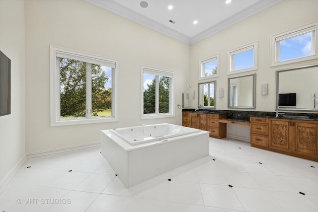 bathroom with ornamental molding, a towering ceiling, vanity, a bathing tub, and tile patterned floors