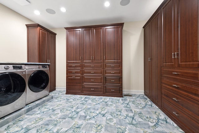 clothes washing area with washing machine and dryer and cabinets