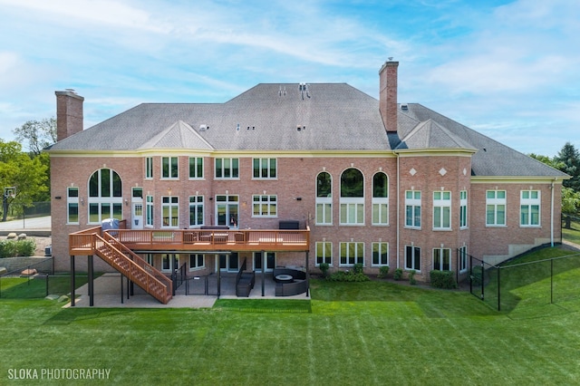 rear view of property featuring a patio, a lawn, and a deck