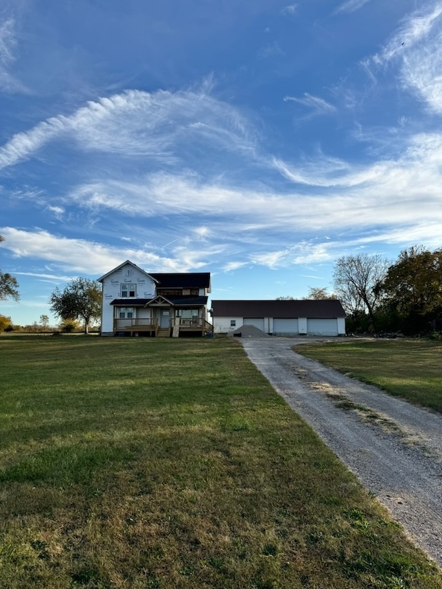 ranch-style home with an outdoor structure, a front yard, and a garage