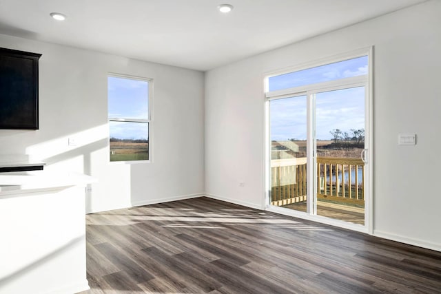 unfurnished living room with plenty of natural light and dark hardwood / wood-style floors