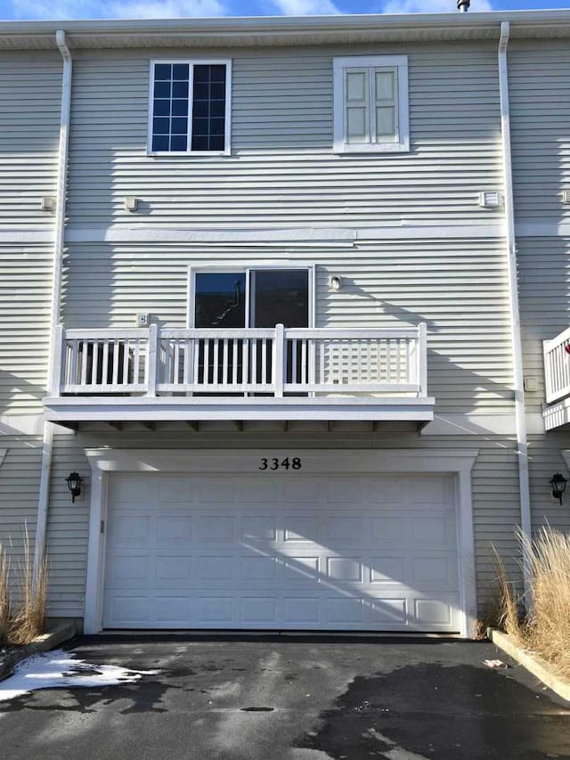 back of house with a balcony and a garage