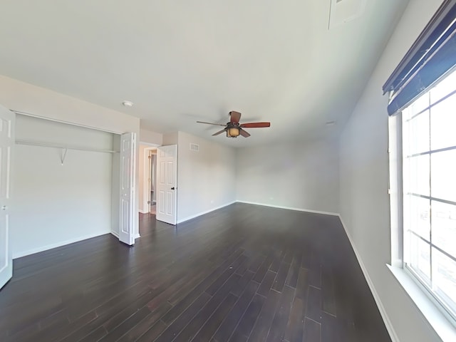 unfurnished living room with ceiling fan, a healthy amount of sunlight, and dark wood-type flooring