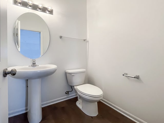 bathroom with toilet and hardwood / wood-style flooring