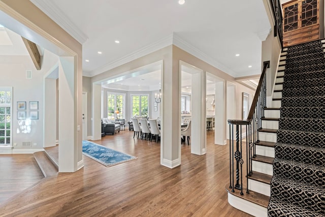 foyer entrance featuring stairway, a healthy amount of sunlight, and wood finished floors