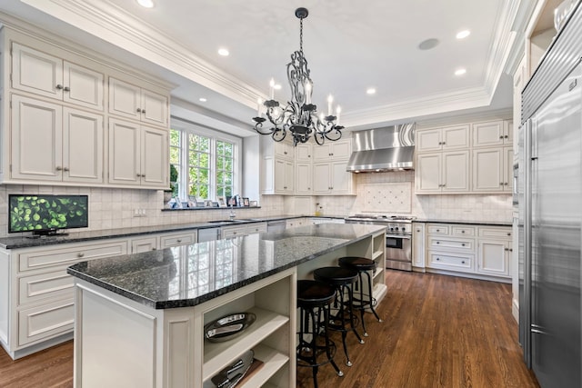 kitchen with open shelves, premium appliances, ornamental molding, and wall chimney range hood