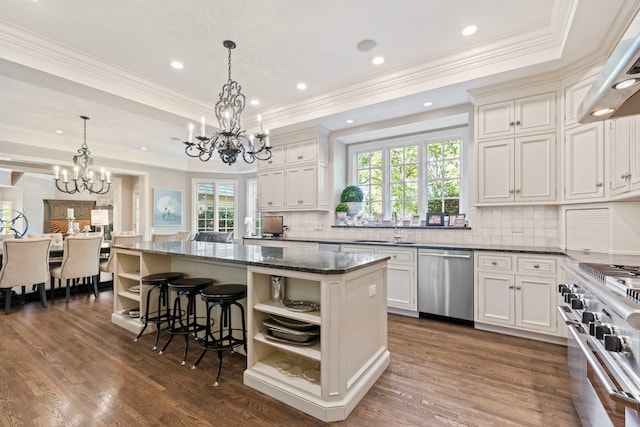 kitchen featuring open shelves, a center island, a chandelier, and appliances with stainless steel finishes