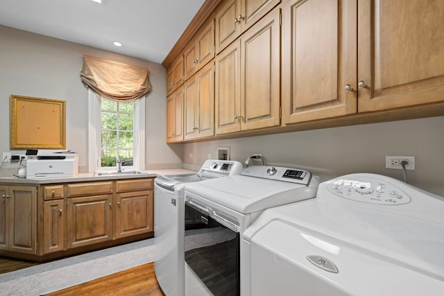 laundry room featuring light wood-style flooring, a sink, washing machine and dryer, recessed lighting, and cabinet space