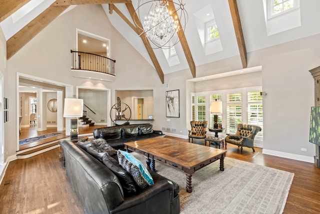living room with beam ceiling, baseboards, a skylight, stairway, and high vaulted ceiling