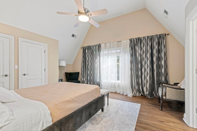 bedroom featuring wood finished floors, vaulted ceiling, visible vents, and ceiling fan