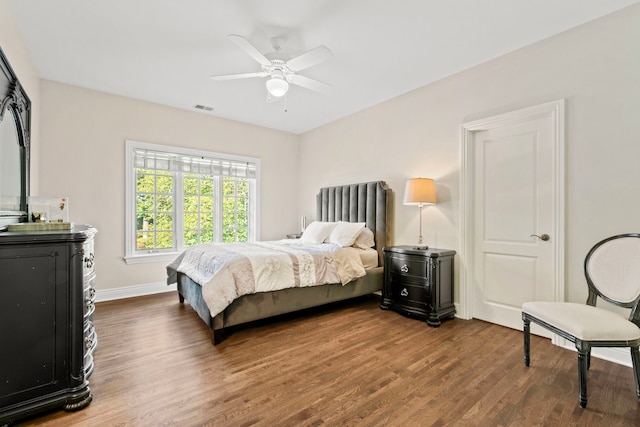 bedroom featuring wood finished floors, visible vents, baseboards, and ceiling fan