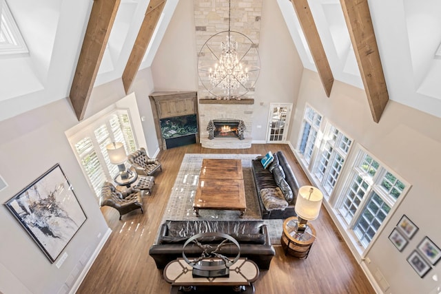 living area featuring beamed ceiling, a chandelier, wood finished floors, and high vaulted ceiling
