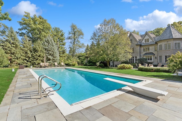 outdoor pool featuring a lawn and a patio area