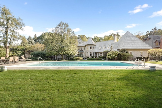 outdoor pool with a patio area and a lawn