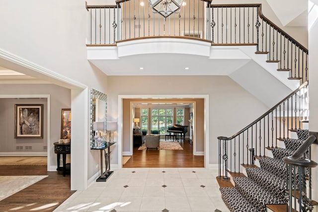 entrance foyer featuring recessed lighting, stairway, a high ceiling, and tile patterned flooring