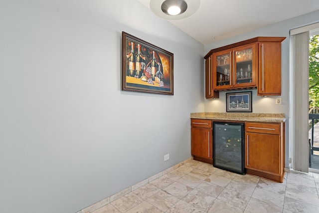 bar with wine cooler and light stone countertops