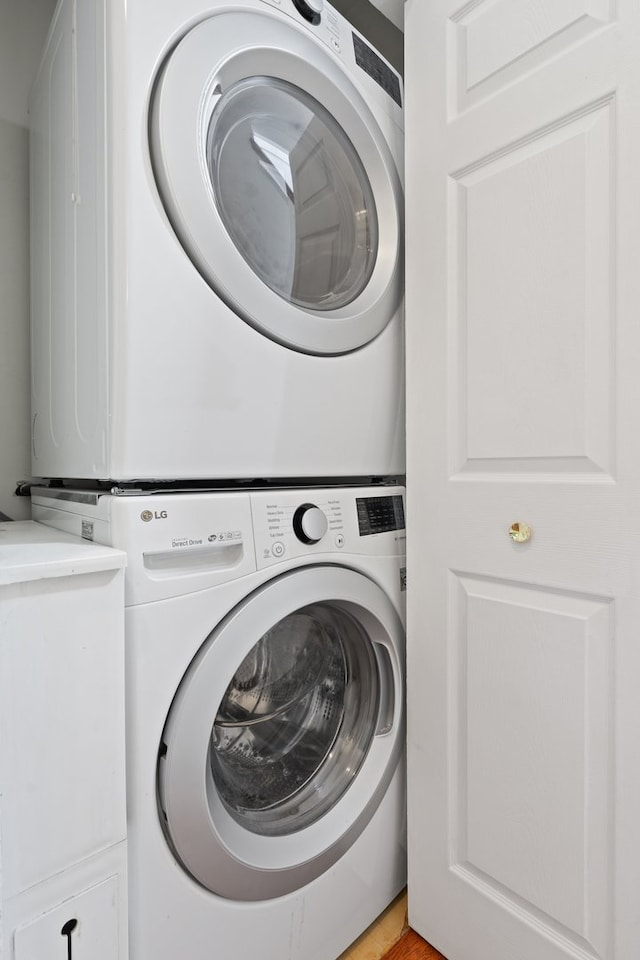 clothes washing area featuring stacked washer and dryer