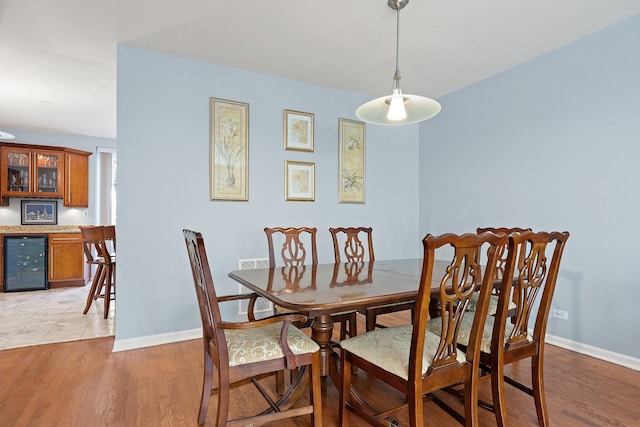 dining room with light hardwood / wood-style floors and beverage cooler