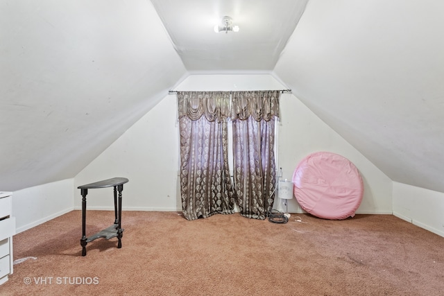 additional living space with light colored carpet and vaulted ceiling