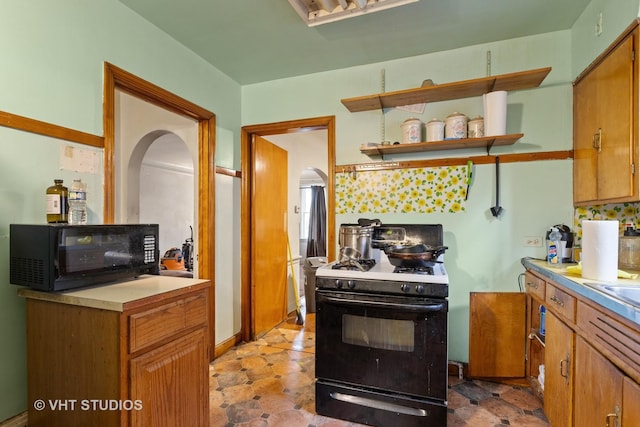 10238 S Vernon Ave, Chicago, IL 60628 - kitchen featuring gas range oven, black microwave, arched walkways, brown cabinets, and light countertops
