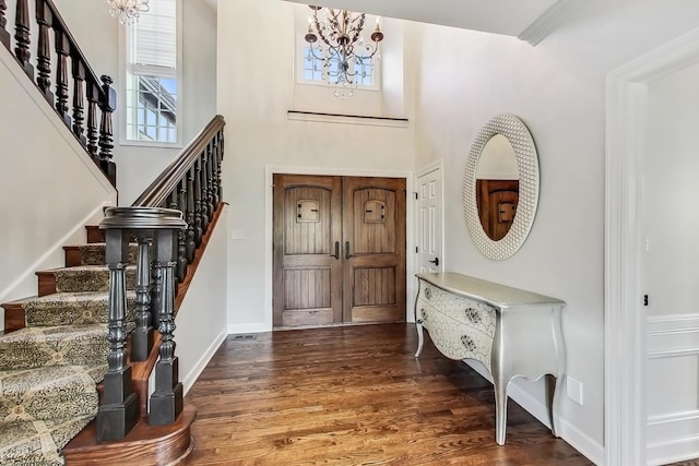 foyer entrance with dark hardwood / wood-style flooring and a chandelier