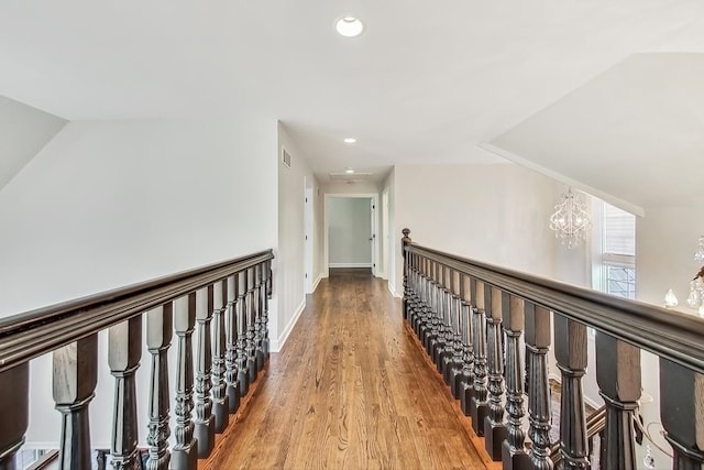 hall featuring hardwood / wood-style flooring and an inviting chandelier