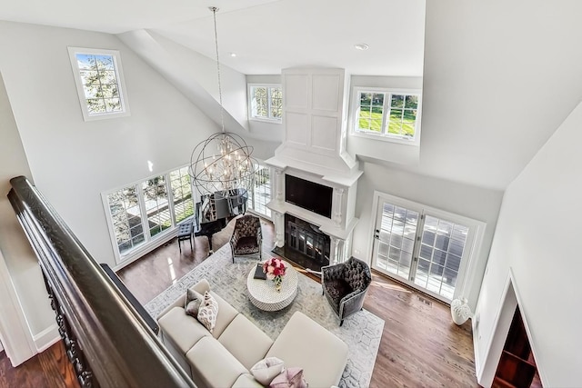 living room featuring a chandelier, a wealth of natural light, high vaulted ceiling, and dark wood-type flooring