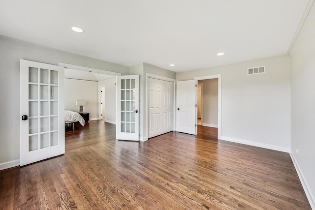 spare room with french doors, dark hardwood / wood-style floors, and ornamental molding