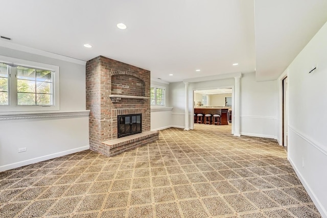 unfurnished living room featuring carpet floors, a fireplace, and a wealth of natural light