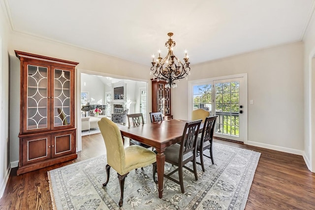 dining room featuring dark hardwood / wood-style flooring, ornamental molding, and a notable chandelier