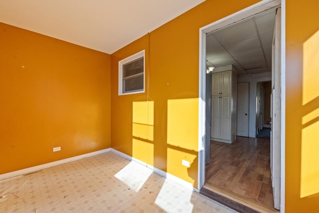 spare room with a drop ceiling and wood-type flooring